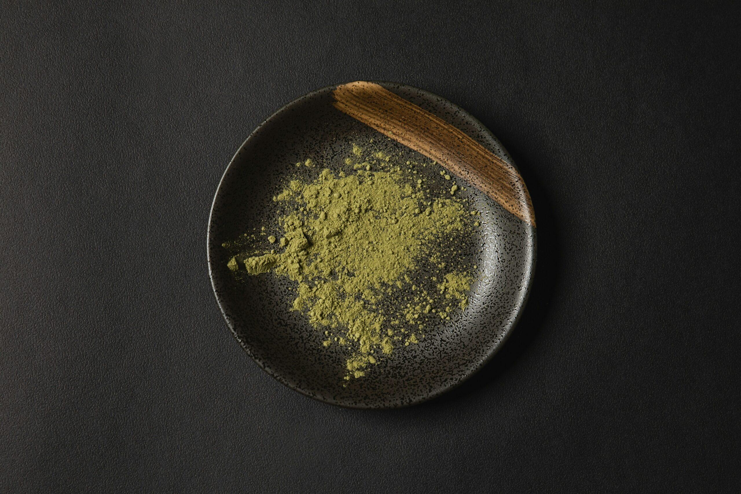 A spoonful of golden turmeric powder against a wooden backdrop