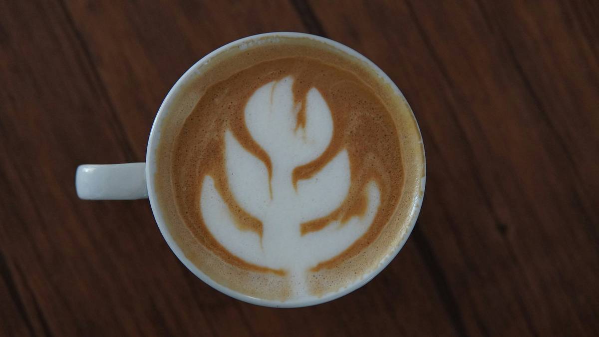 Step-by-step process of preparing a frothy turmeric latte in a small saucepan