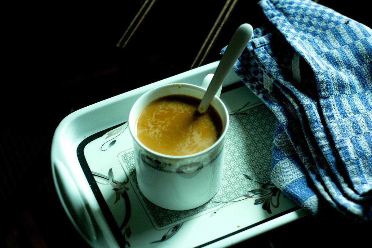 A young woman sipping golden milk while reading a book indoors