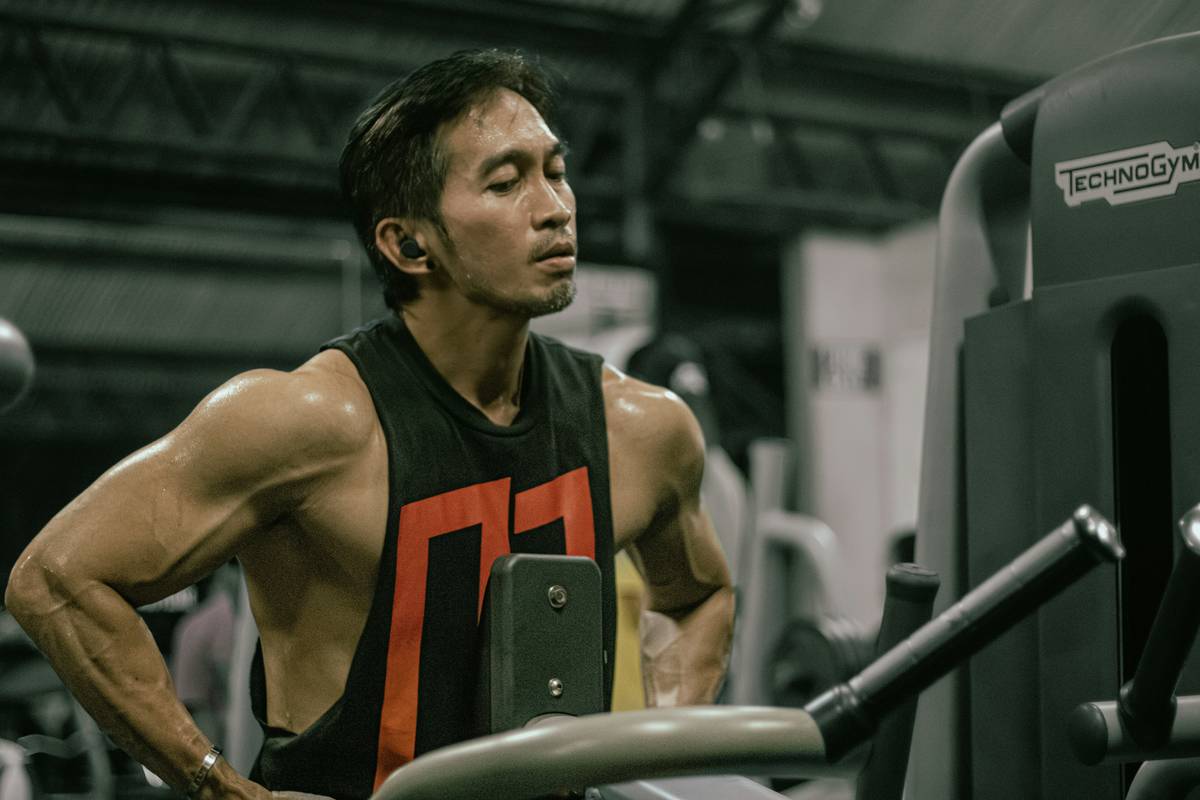 A glass jar filled with a golden-yellow turmeric smoothie beside fresh ingredients