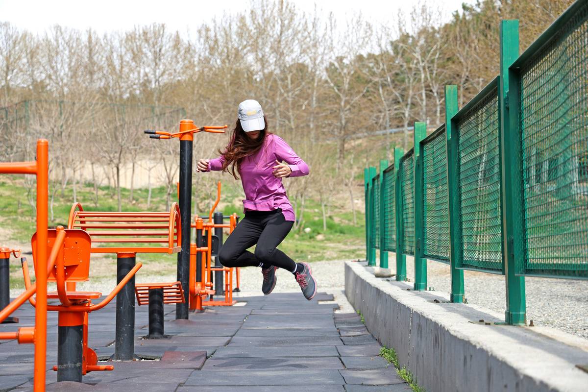Turmeric powder and fresh turmeric roots in a wooden bowl