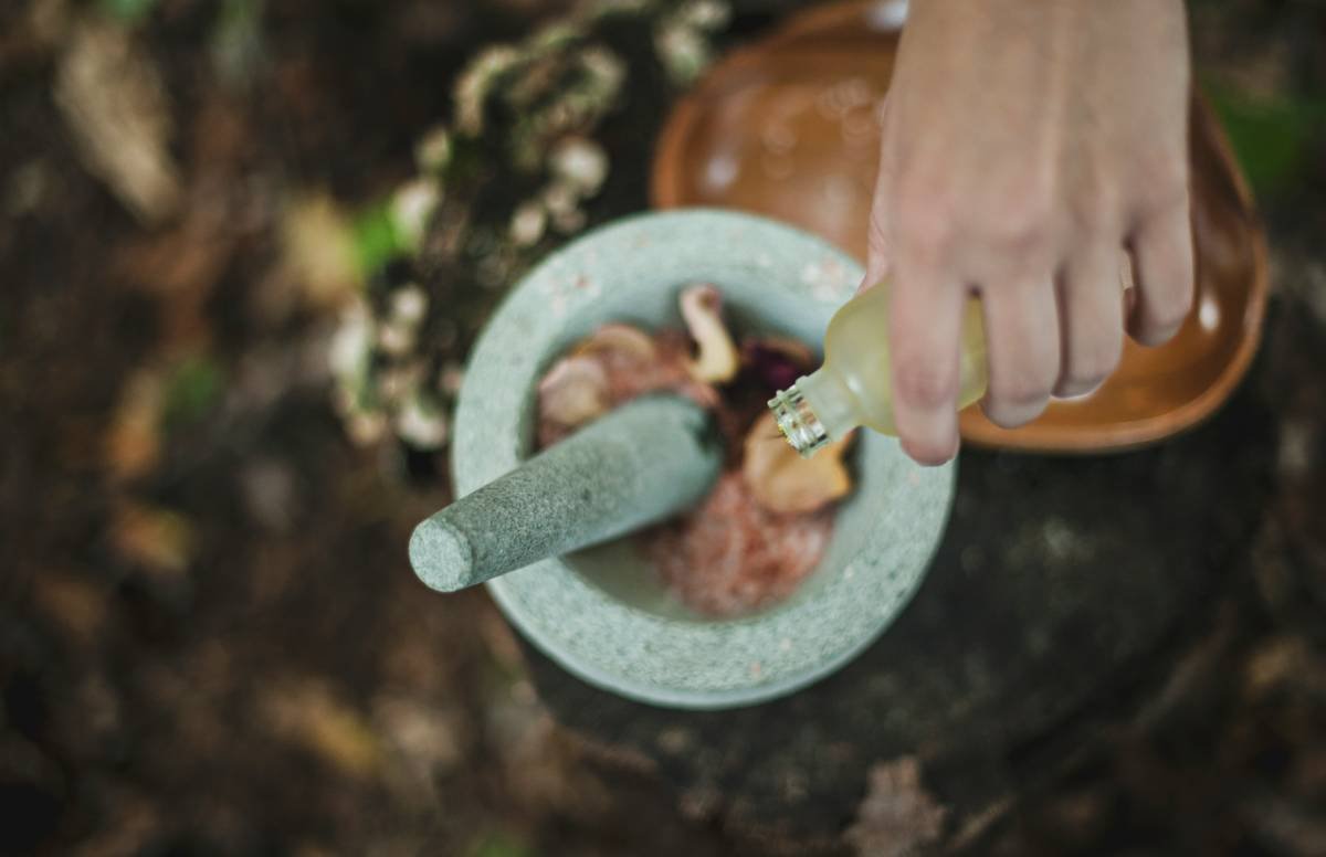 A bowl of fresh turmeric root and powder on a wooden table