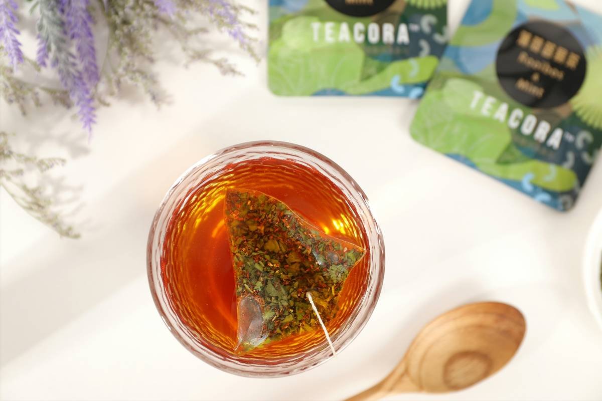 Turmeric powder and root on a wooden spoon